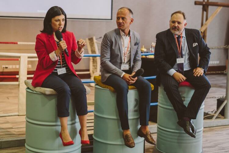 Panelists sitting on barrels answering questions