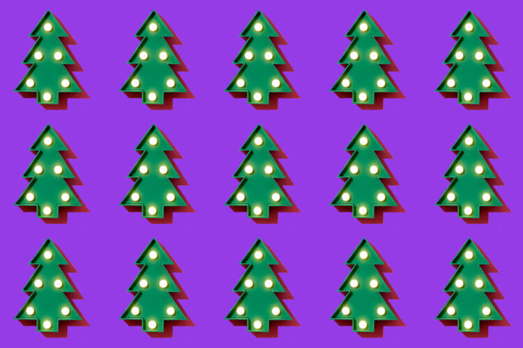 a header image for slido's christmas themed blog depicting 15 christmas trees on a solid purple background