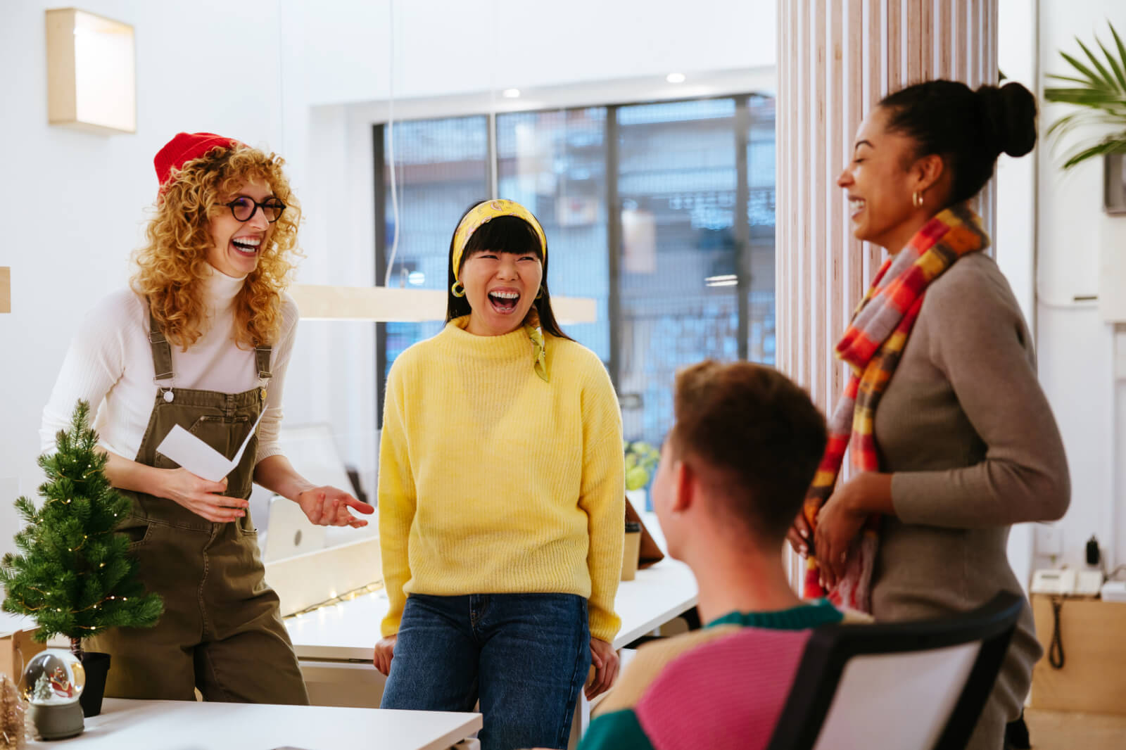 a picture of four colleagues having fun at a end-of-year meeting serving as a header image for an article on the Slido blog