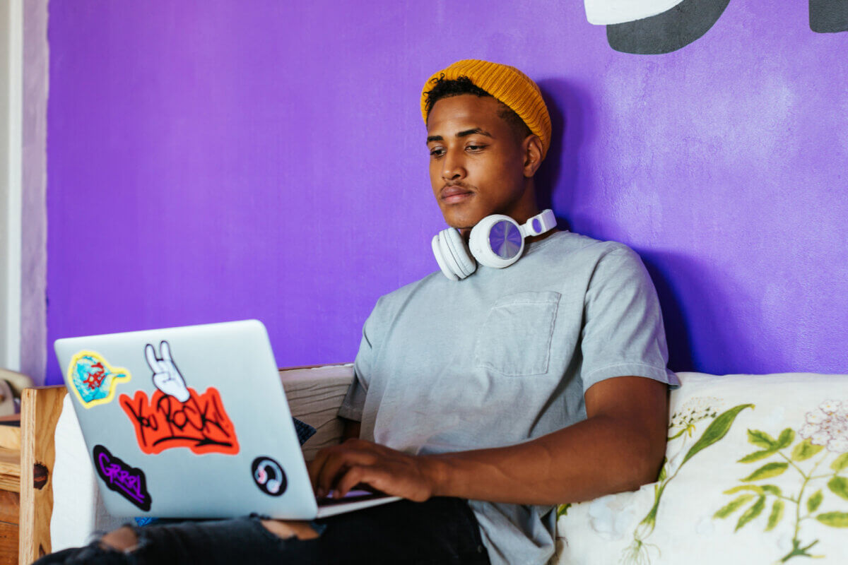 a young man sitting behind a computer studying as an illustration image for a slido's blog about asynchronous learning