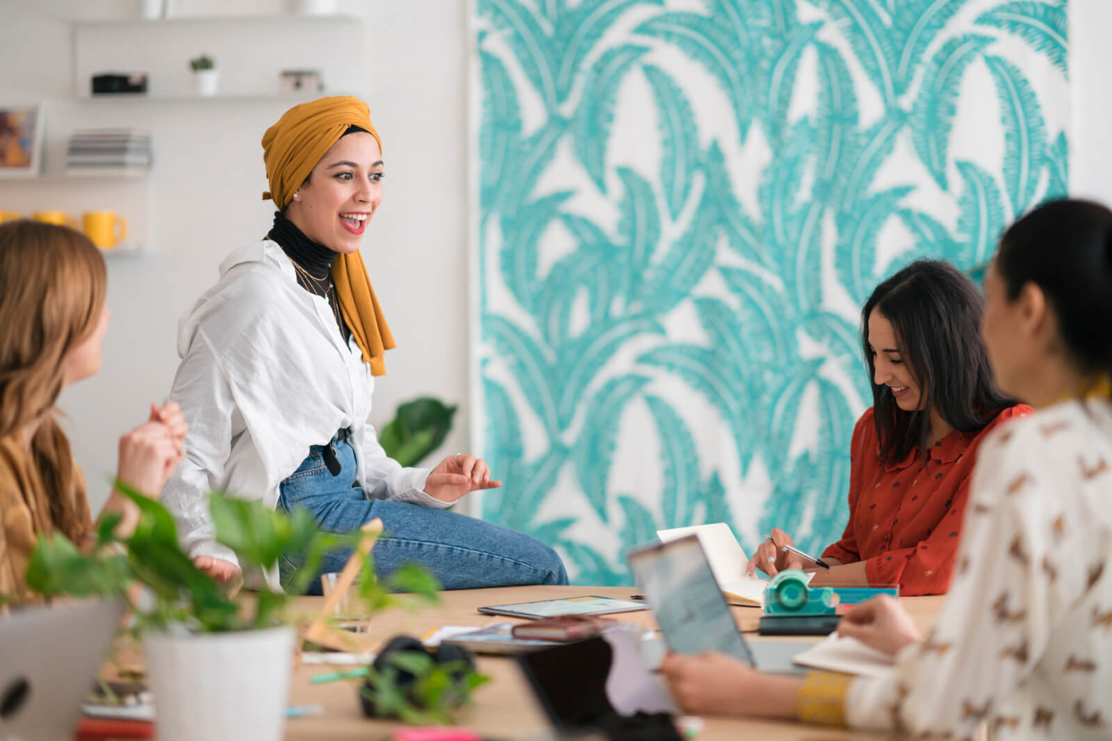 a picture of a young business professional running a meeting with her coworkers used as a featured image for a slido blog post about hosting more effective meetings by collecting input in advance