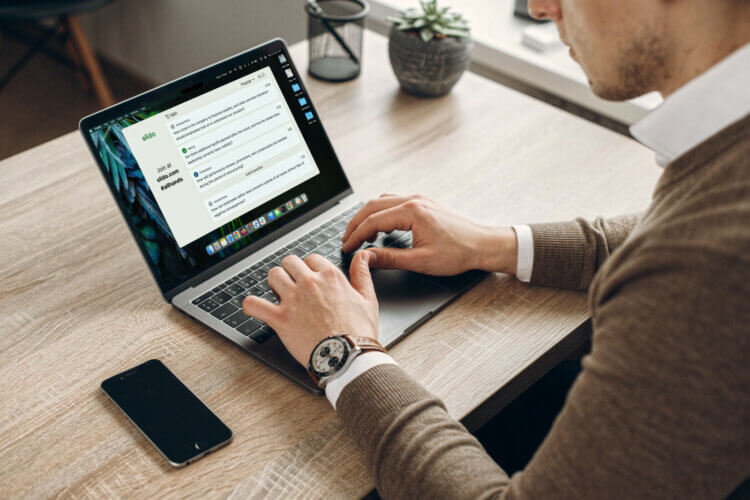 A leader typing on a laptop preparing for a meeting