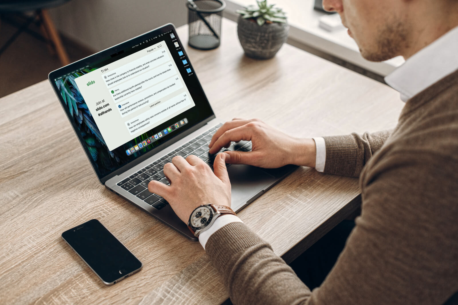 A leader typing on a laptop preparing for a meeting